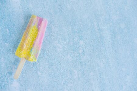 Rainbow ice cream with place for text on a blue background. Homemade yogurt ice cream. Summer dessertsの写真素材