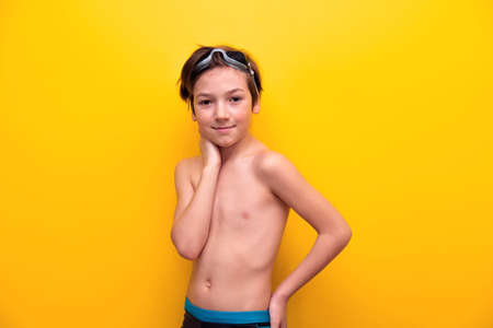 Cheerful boy tourist 9 years old on a yellow background. Marine entertainment. Tourist banner with boyの写真素材