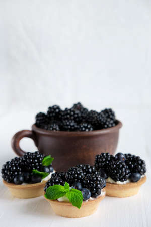 Fresh blackberries. Homemade tortillas with blackberries. Summer desserts with berries that are good for your health. Vertical photo with bramble and place for an inscription