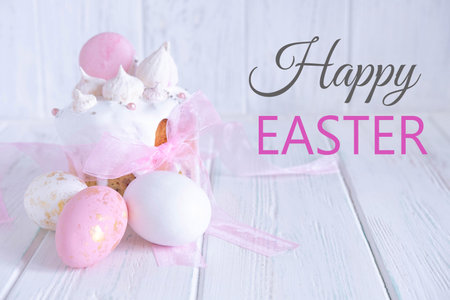Greeting Easter card. Easter cake, eggs with a congratulatory inscription on a light wooden background.の写真素材