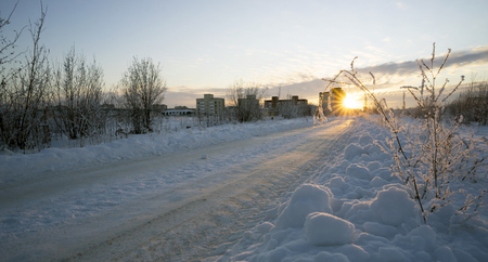Winter road leading to  house at sunset.の写真素材