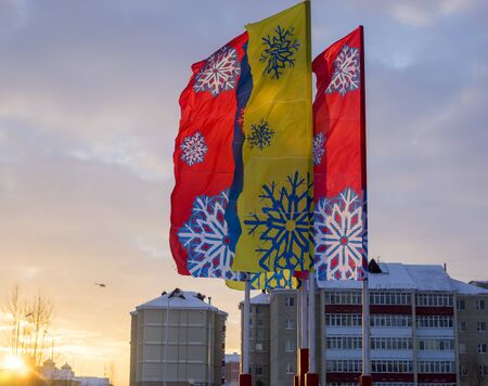 Multi-colored flags, with painted snowflakes in winter.City landscape.の写真素材