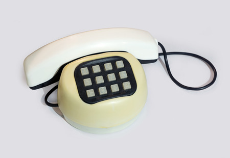 Old plastic push-button telephone on a white background.の写真素材