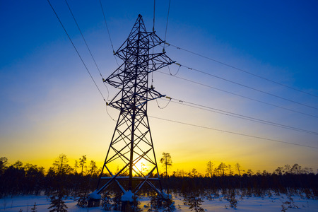 Line of electricity transmission in the winter at sunset.