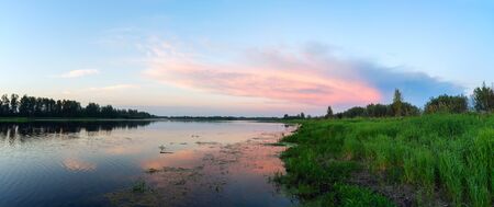 Evening landscape with pink clouds over the lake.の写真素材