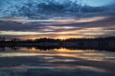 Mirror image of the sunset on the lake in spring.の写真素材