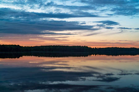 Colorful sunset on a forest lake in summerの写真素材