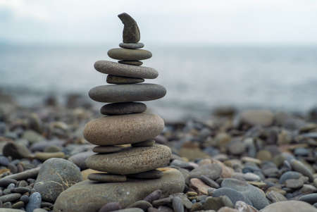 A pyramid of sea stones on the background of the sea