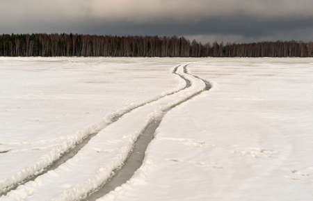 Winding wheel tracks on a frozen lake. Winter day. Leningrad region.の写真素材