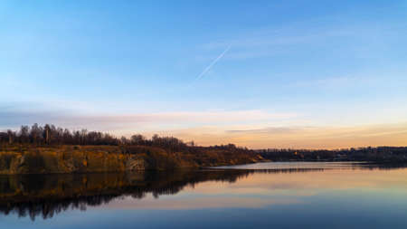 The windless surface of the lake and the reflection of clouds on calm water. Leningrad region, Vsevolozhsk.の写真素材