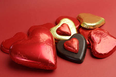 Red and gold wrapped chocolates against a red background for Valentine, or saying, I Love You の写真素材