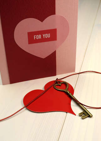 Love theme  Key to my Heart  concept with heart shape brass gold key and red heart on white shabby chic table, with handmade card の写真素材