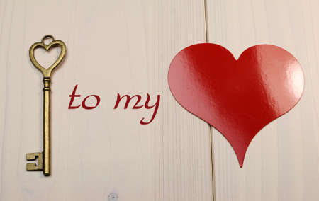 Love theme  Key to my Heart  concept with heart shape brass gold key and red heart on white shabby chic table の写真素材