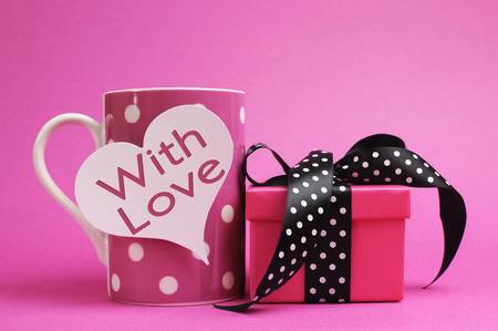 Cute and sassy pink mug and gift with polka dot ribbon on pink background の写真素材