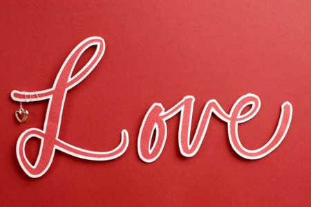 Love spelt in letters with cute heart against a red background, for Valentine or special greeting 