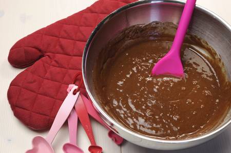 Valentine, birthday or special occasion cooking chocolate muffins with red glove and heart shape measuring spoons on vintage shabbby chic natural white wood table の写真素材