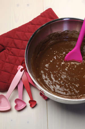 Valentine, birthday or special occasion cooking chocolate muffins with red glove and heart shape measuring spoons on vintage shabbby chic natural white wood table  Vertical の写真素材