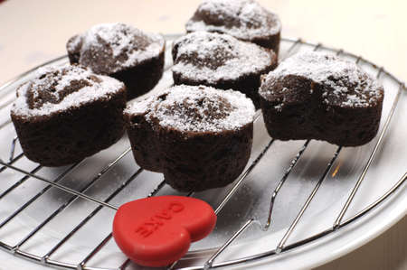 Valentine, birthday or special occasion homemade baked heart shape chocolate chip muffins against a vintage, shabby chic white wood table  Close up の写真素材