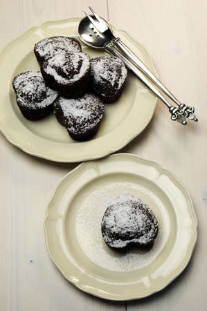 Valentine, birthday or special occasion homemade baked heart shape chocolate chip muffins against a vintage, shabby chic white wood table, aerial view の写真素材