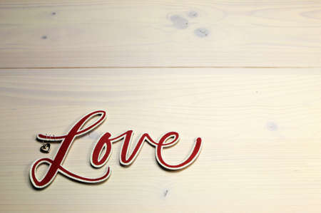 The word, Love, spelled in red script letters on white shabby chic tableの写真素材