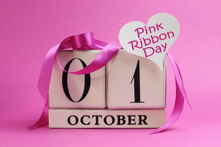 Save the date white calendar for October 1, Pink Ribbon Day, with pink ribbons and heart sign message against a pink background の写真素材