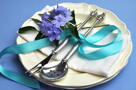 Blue theme table setting with beautiful silver cutlery, plates and serviette napkins for a modern twist on traditional table setting elegance の写真素材