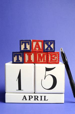 Save the Date, April 15, USA Tax Day with white calendar and red, white ad blue building block letters on blue background  Vertical with copy space の写真素材