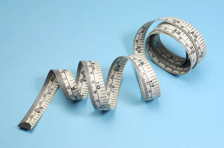 White tape measure on blue background for slimming and weight loss diet or fitness concept 