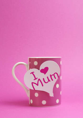Pink polka dot coffee or tea mug with heart shape white gift tag with I Heart Love Mum for Mothers Day on pink background with copy space for your text here の写真素材