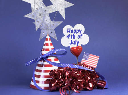 Happy Fourth 4th of July party table decorations with hat, streamers, sign, flag and stars in USA America red, white and blue theme.の写真素材