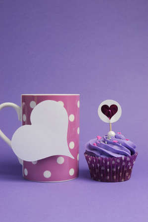 Mauve purple decorated cupcakes for children or teens birthday, or bachelorette, bridal or baby shower party function, with pink polka dot coffee mug and heart gift tag with copy space for your text here の写真素材