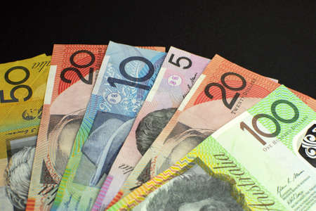 Australian paper money, including one hundred, twenty, ten, five and fifty dollar notes against a black background, with copy space at top の写真素材