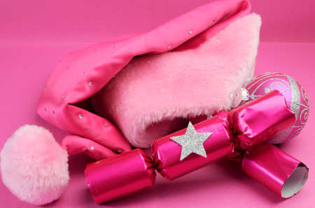 Pretty pink feminine santa hat with festive Christmas decorations on pink background.の写真素材