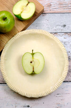 Holiday festive baking with an empty pie shell pastry crust with raw green apple ingredients.の写真素材