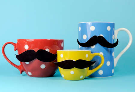 A family of mustaches on blue, red and yellow polka dot coffee and tea cups and mugs,  for november to raise awareness for male health problemsの写真素材