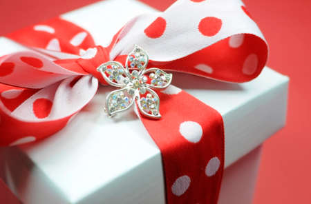 Red and white polka dot theme gift box present with heart shape gift tag, with love, for Christmas, Valentine, birthday, wedding or special occasion.の写真素材