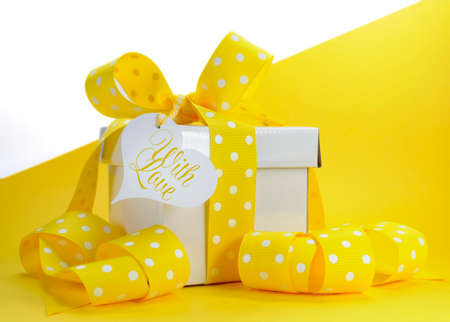 Yellow theme gift box with yellow polka dot ribbon and white copy space for Easter, birthday,...