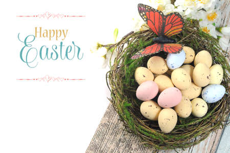 Happy Easter shabby chic table with speckled birds eggs and butterfly in nest with spring blossoms and sample text or copy space for your text here の写真素材