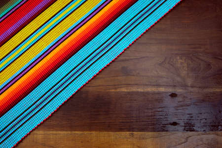 red, yellow and blue colors against dark wood recycled timber table の写真素材