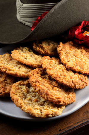 Australian army slouch hat and traditional Anzac biscuits on dark recycled woodの写真素材