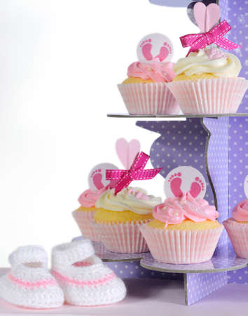Pink theme baby girl cupcakes and booties on purple polka dot cupcake stand の写真素材