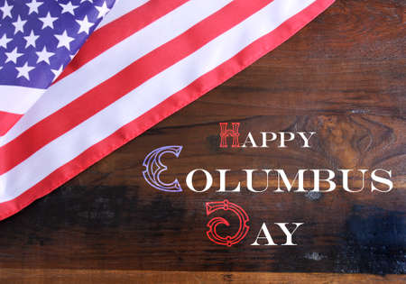 Happy Columbus Day greeting message text on dark rustic recycled wood background with USA stars and stripes flag.の写真素材