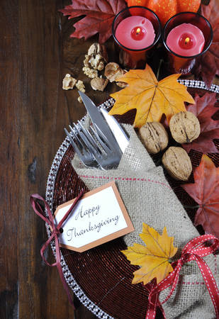 Happy Thanksgiving dining table place setting in traditional rustic country style with hessian wrapped cutlery on rustic wood background.の写真素材