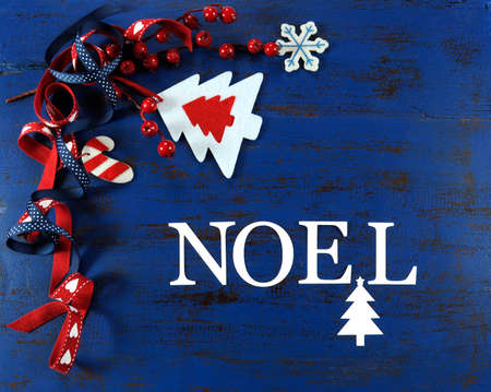 Christmas holiday festive natural style wood and felt ornaments on a dark royal blue vintage recycled wood background, with Noel greeting letters.の写真素材