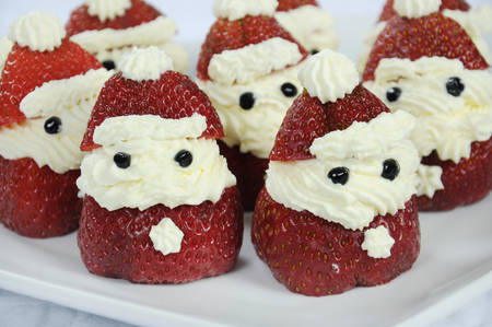 Christmas holiday Strawberry Santas dessert party food in modern red and white theme - closeup.の写真素材