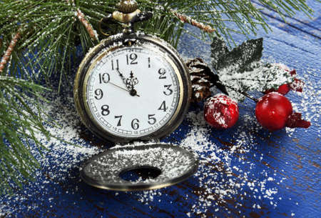 Happy New Year pocket fob watch with five to midnight time and decorations on dark blue rustic...