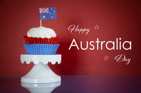 Happy Australia Day, January 26th, party food with red, white and blue cupcakes and Australian flags on red and blue background with sample text greeting.の写真素材