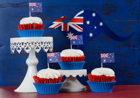Happy Australia Day January 26 party food with red velvet cupcakes with kangaroo flag on dark red and blue vintage rustic recycled wood background.の写真素材