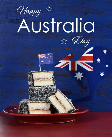 Happy Australia Day January 26 party food with iconic Australian lamington cakes on dark red and blue vintage rustic recycled wood background, with sample text.の写真素材
