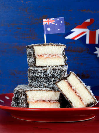 Happy Australia Day January 26 party food with iconic Australian lamington cakes on dark red and blue vintage rustic recycled wood background.の写真素材
